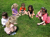 Børn i rundkreds på græsplæne